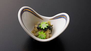 A white bowl with blue and yellow stripes on a black surface.