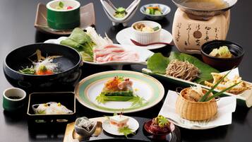 A variety of Japanese dishes arranged on a table, including sushi, sashimi, and other delicacies.