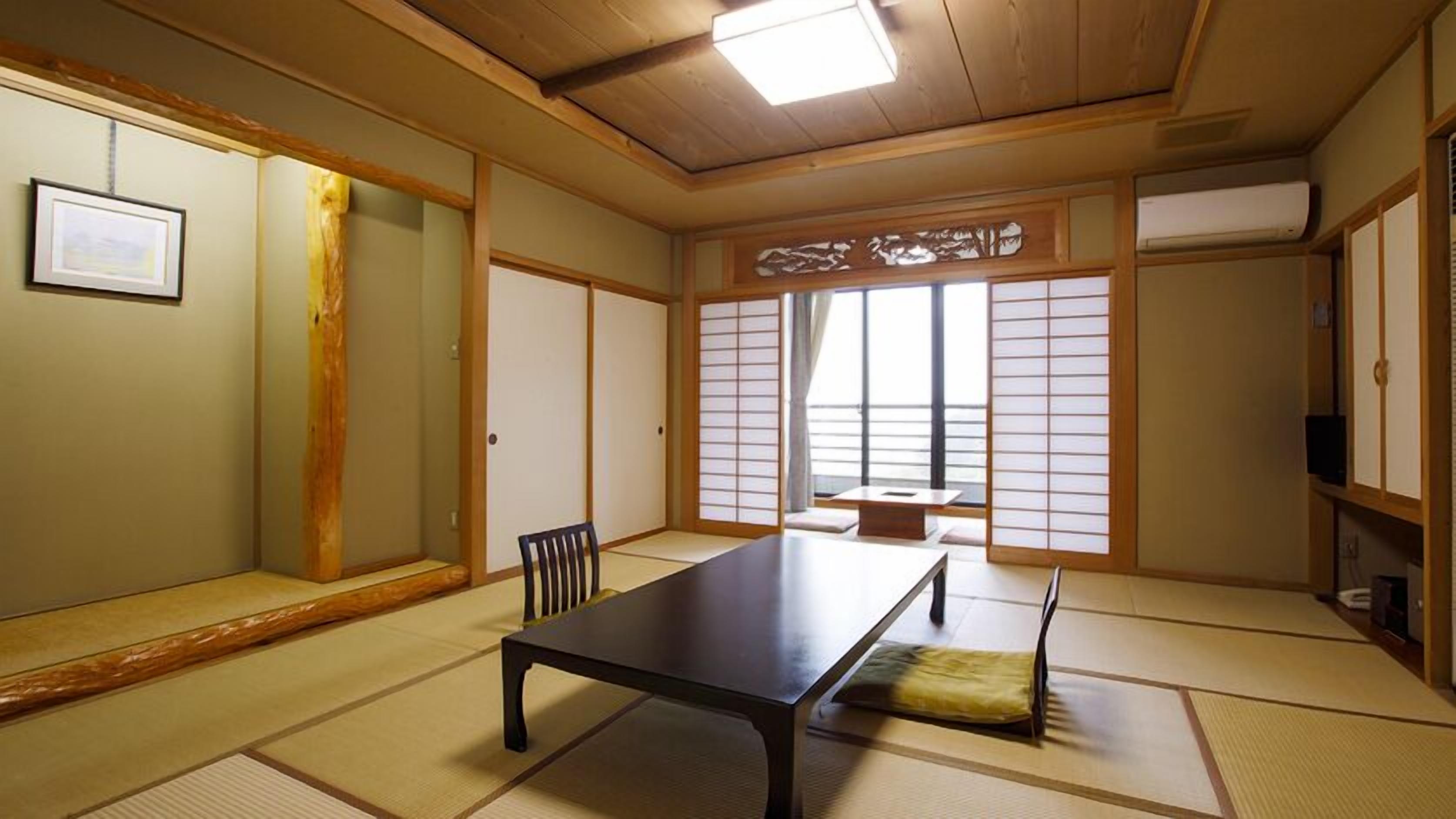 Une pièce de style japonais traditionnel, avec un sol recouvert de tatamis, une table basse, une chaise, des portes coulissantes et une vue à travers des panneaux shoji.