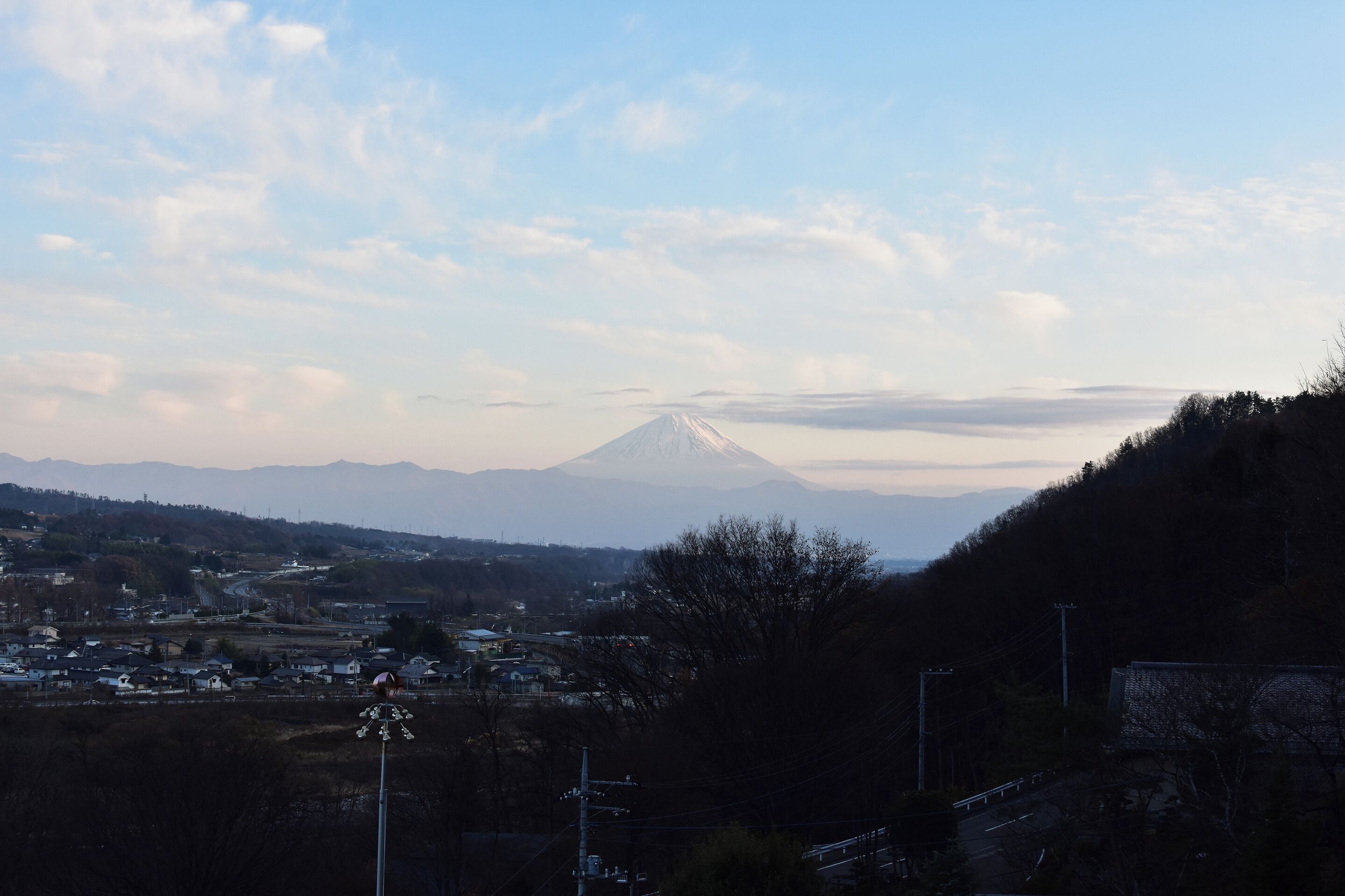 A view of a mountain with a town in the foreground and a clear sky.