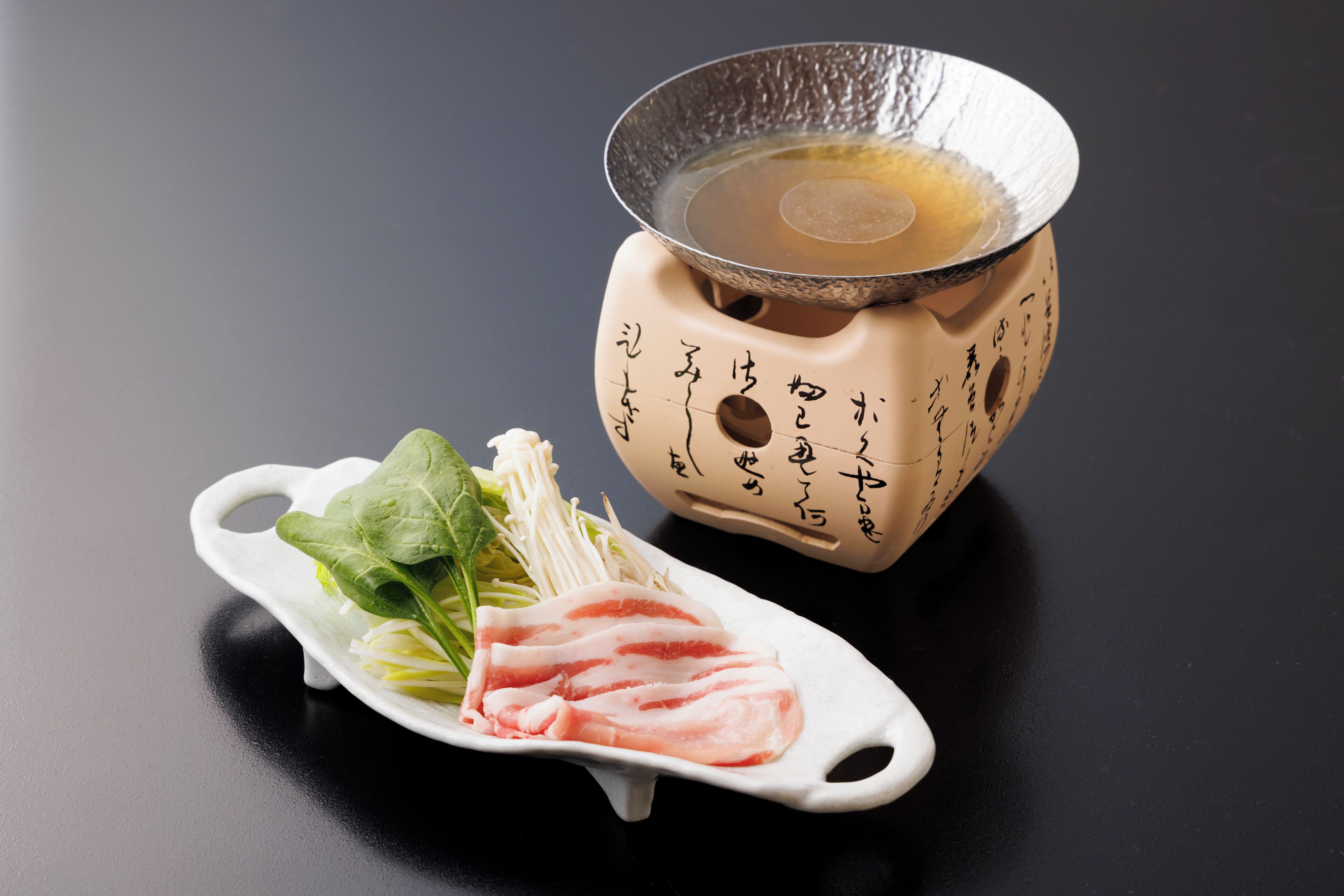 Jogo de chá japonês tradicional com bule e xícara de cerâmica, acompanhados de um prato de cerâmica branco com carne e legumes fatiados.
