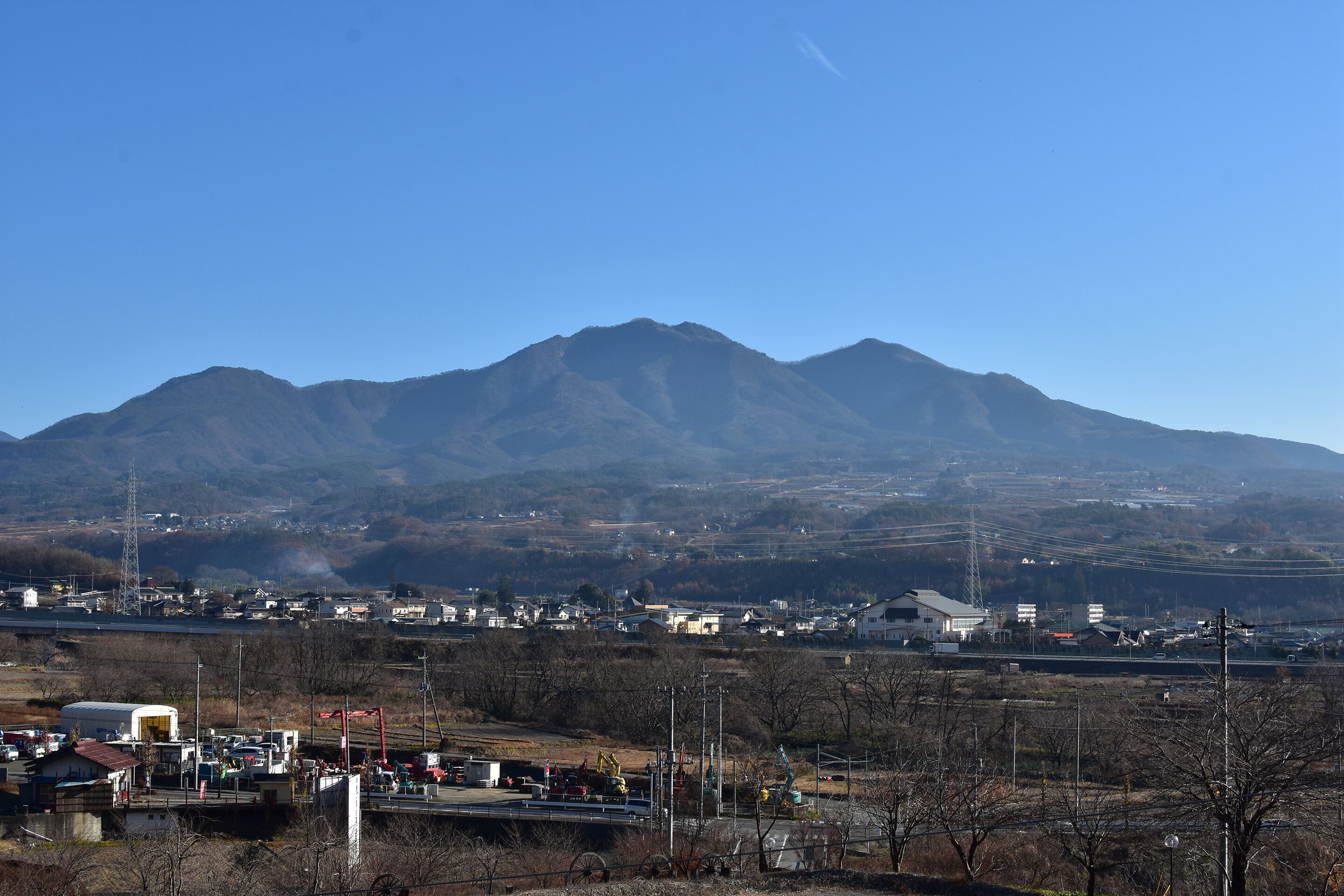 A mountainous landscape with a town in the foreground and a clear sky.