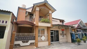 A two-story residential building with a balcony, a gated entrance, and a water tank on the roof. - Hotel O Az Zahra Residence Syariah (Surabaya)