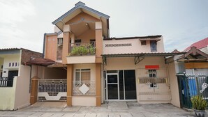 A two-story building with a balcony, a gated entrance, and a sign indicating it is a school. - Hotel O Az Zahra Residence Syariah (Surabaya)