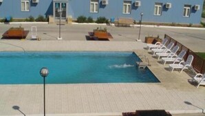 A swimming pool with lounge chairs and a lamp post.