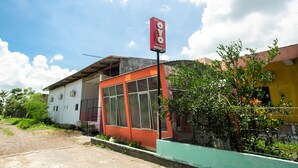 A building with a large sign reading "OYO" and a red door. - OYO 2415 Ibma Smart Syariah (Pandaan)