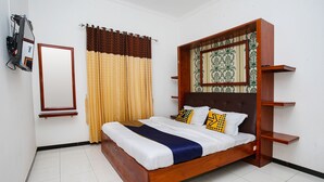 A bedroom with a wooden bed, a mirror, curtains, and a patterned wall. - OYO 2718 Backpacker's Homestay Jlegong (Wonosobo)
