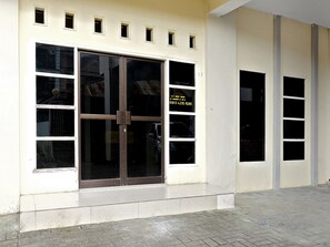 A building facade with a large glass door and multiple windows.
