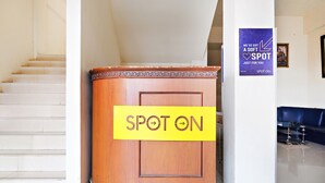 A reception desk labeled "SPOT ON" with a staircase in the background.