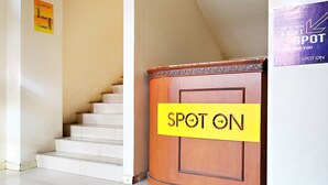 A staircase with a 'SPOT ON' sign on the wall and a wooden podium with a 'SPOT ON' sign.