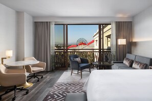 A hotel room with a bed, a desk, two armchairs, a sofa, and a view of a Ferris wheel. - The Westin Anaheim Resort (Anaheim)