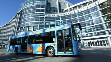 A blue bus with "Special" and "Smart" branding parked in front of the Anaheim Convention Center.