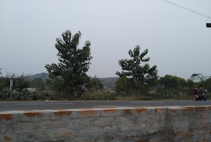 Roadside scenery with a motorcyclist on a hilly landscape.
