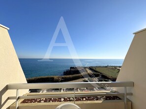 Un balcon avec vue sur la mer et une côte rocheuse.