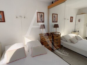 1 dormitorio y tabla de planchar con plancha