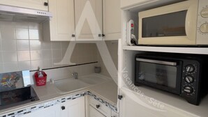 A kitchen with white cabinets, a microwave, a toaster, and a sink.