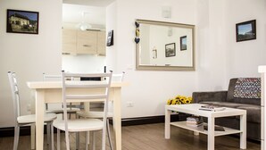 A modern living room with a dining area, a sofa, and a coffee table. - Beautiful apartment for 4 people with WIFI, TV, patio and pets allowed (Ovasta)