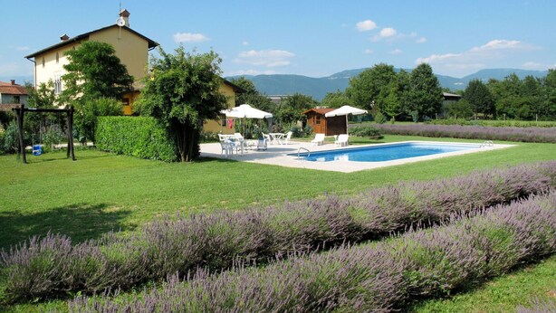 A backyard with a swimming pool, outdoor seating, and a house. - Cosy apartment in villa for 4 people with A/C, WIFI, pool, TV, terrace and pets allowed (Povoletto)
