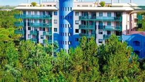 Un hôtel moderne à plusieurs étages, doté de balcons et entouré de verdure.