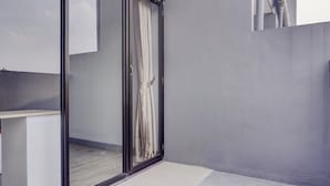 Ein modernes Badezimmer mit Duschkabine aus Glas, einem weißen Waschbecken und einem grauen Fliesenboden.
