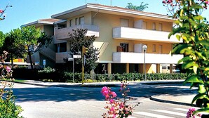 Un immeuble de deux étages, doté d’un toit plat et d’un balcon à l’étage supérieur.