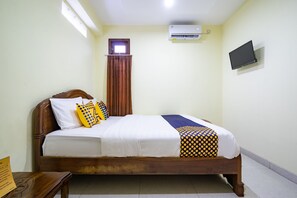 A neatly made bed with a white and patterned bedspread, a wooden headboard, and a small window above the bed. - Hotel O Nabila Homestay (Ngaglik)