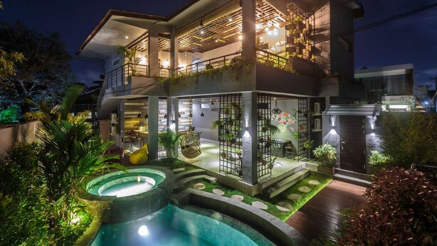 A two-story house with a swimming pool, outdoor seating, and a balcony with plants. - 7Room Villa in central Seminyak | Private Pool & 7BR (Kabupaten Badung)