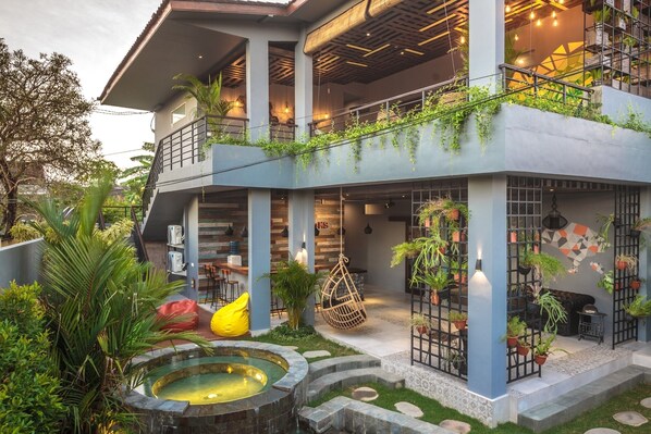 Um edifício moderno com jardim no terraço, área de estar externa e banheira de hidromassagem.