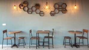 A dining area with hexagonal wooden wall decorations and hanging pendant lights. There are four wooden tables and six chairs. - 7Room Villa in central Seminyak | Private Pool & 7BR (Kabupaten Badung)