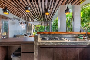 A modern kitchen with a gas stove, a sink, and pendant lighting.