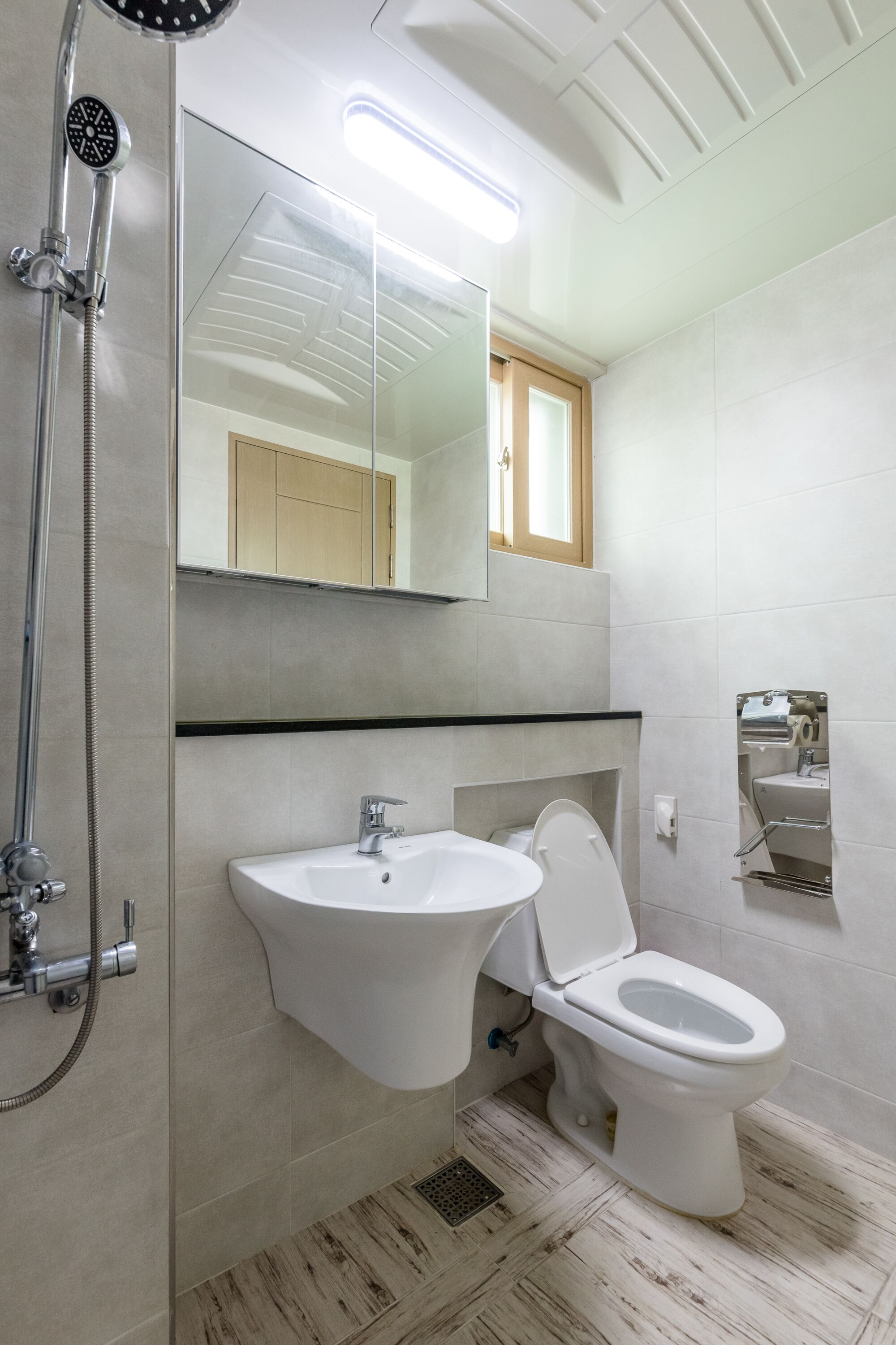 Ein modernes Badezimmer mit Dusche, Waschbecken und Toilette.