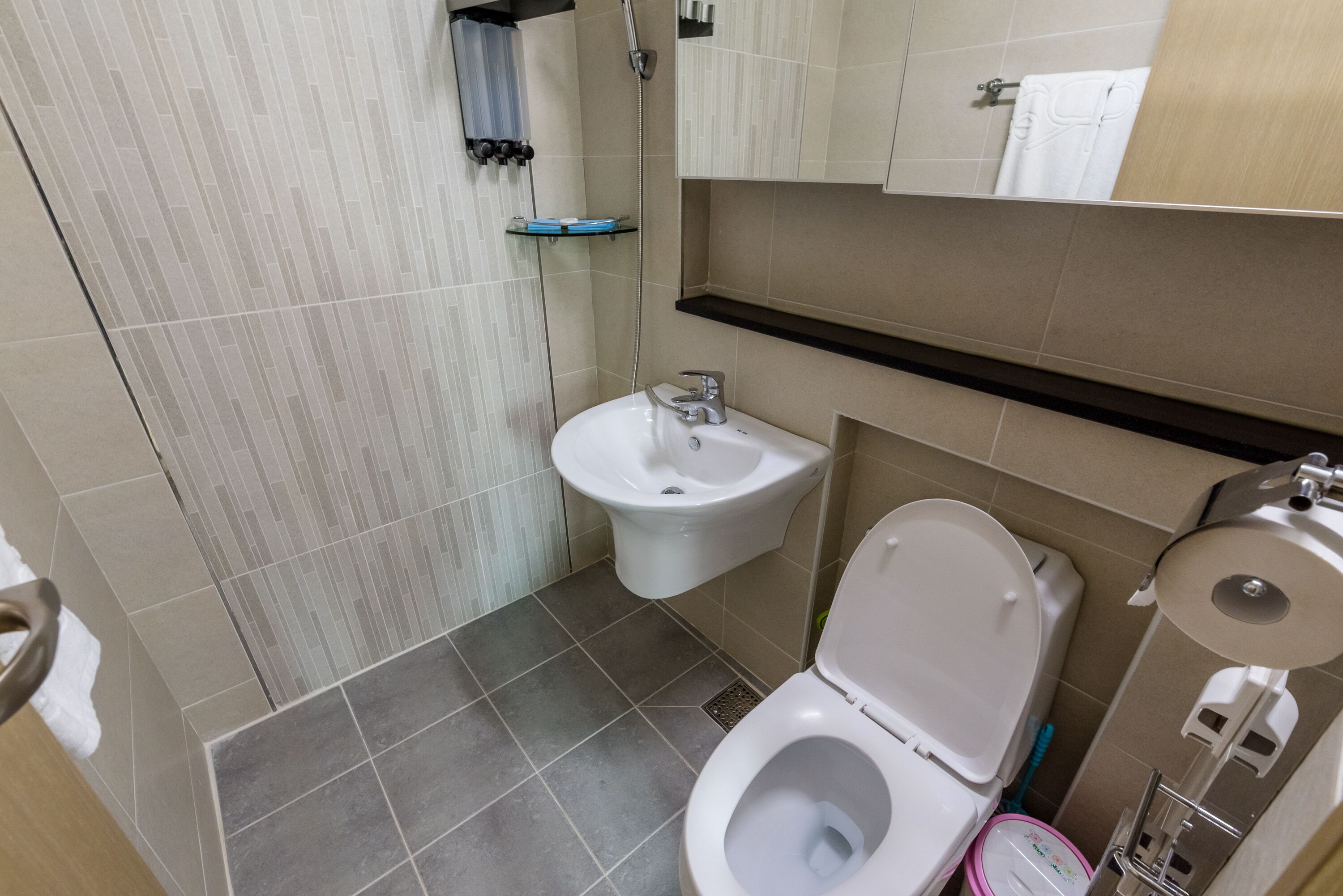 A bathroom with a bidet, toilet, and sink.