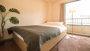 A bedroom with a bed, a potted plant, a floor lamp, and a view of the outside. - SAKIZO VILLA Kyoto Jingu-michi Sanjo 304 (Kyoto)