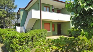 Een herenhuis met een balkon, omgeven door groen.