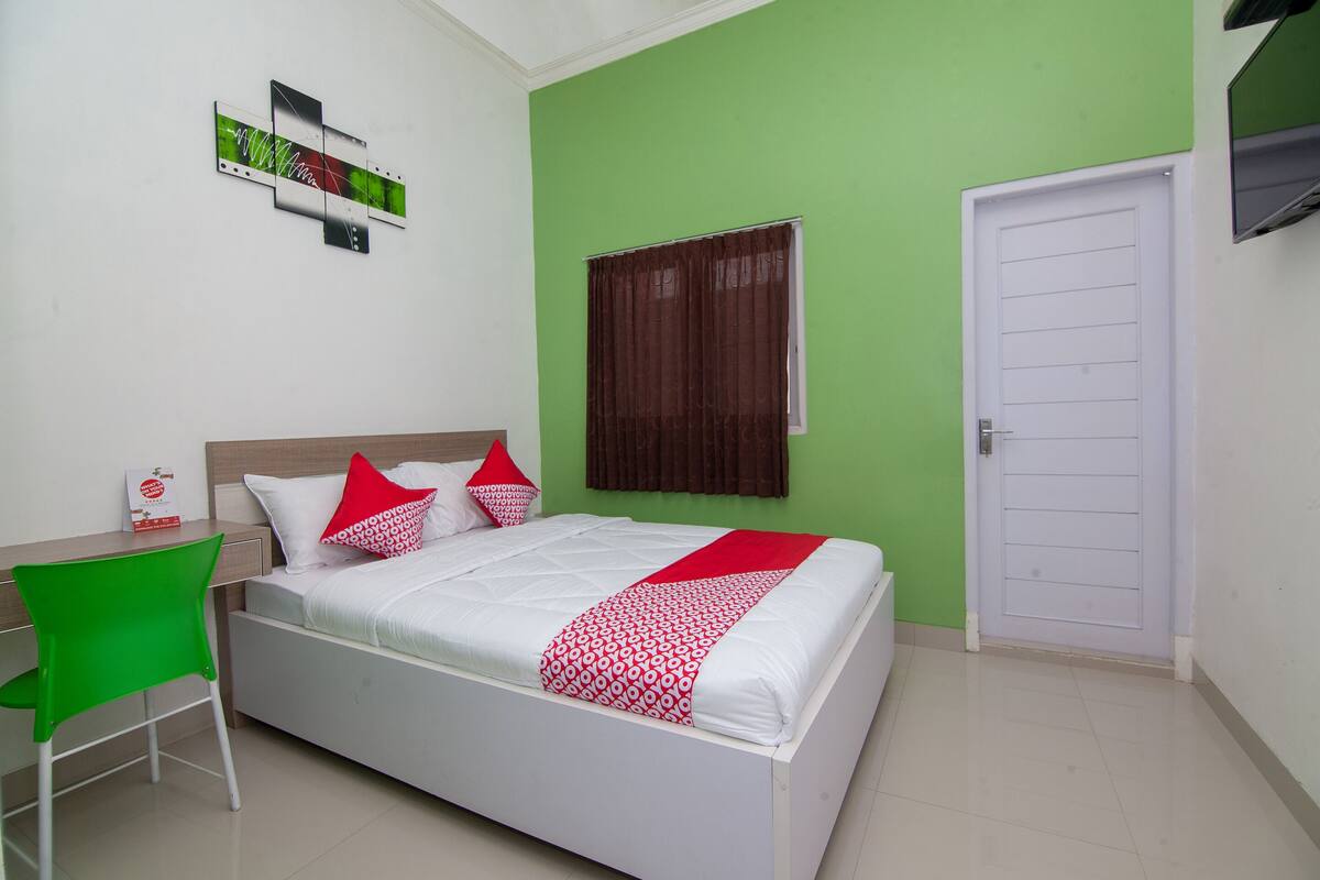 Quarto bem organizado com uma cama, uma escrivaninha e uma cadeira.