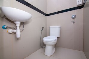 Un baño con lavamanos, inodoro y ducha blancos.