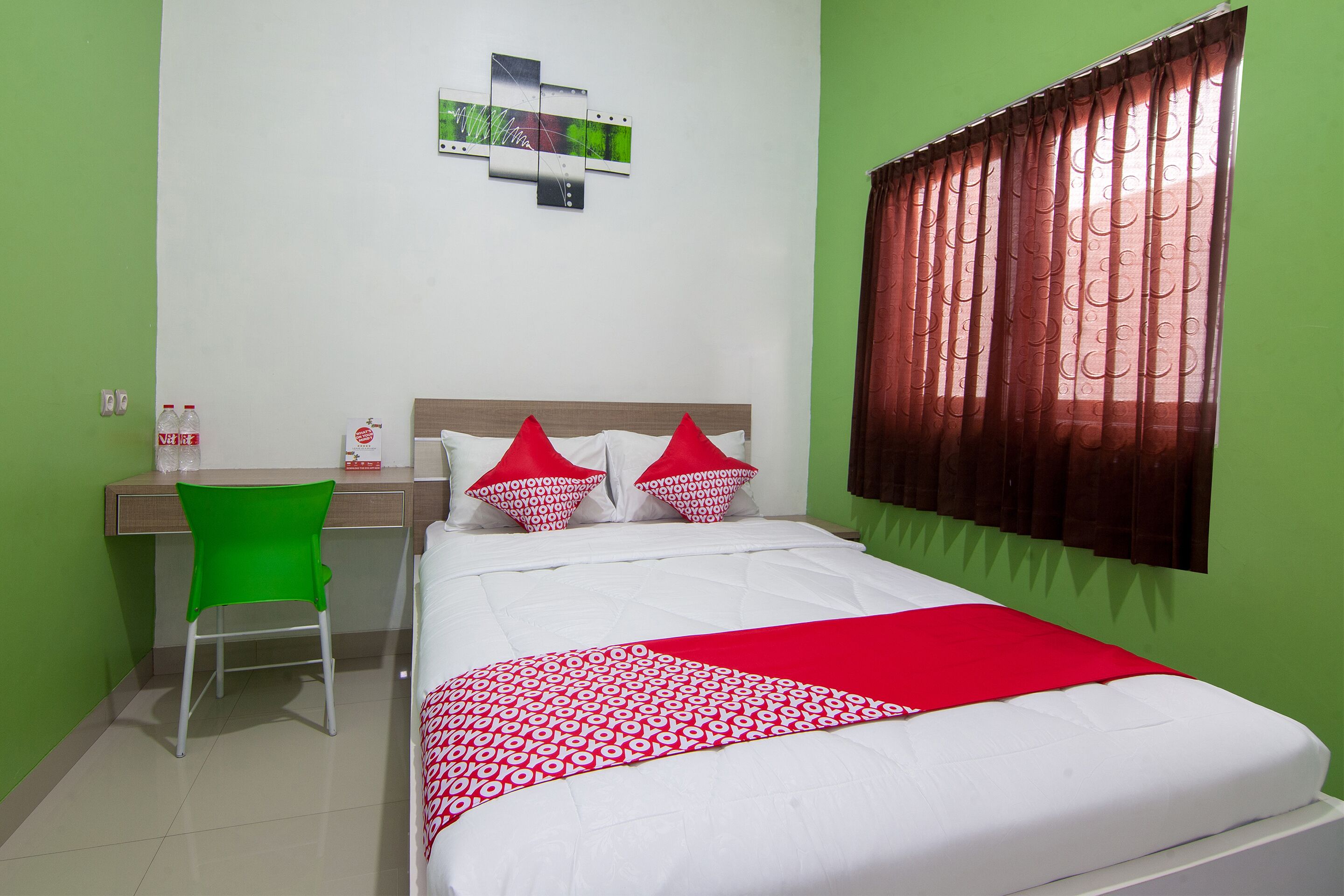 A neatly arranged bedroom with a bed, a desk, and a chair.