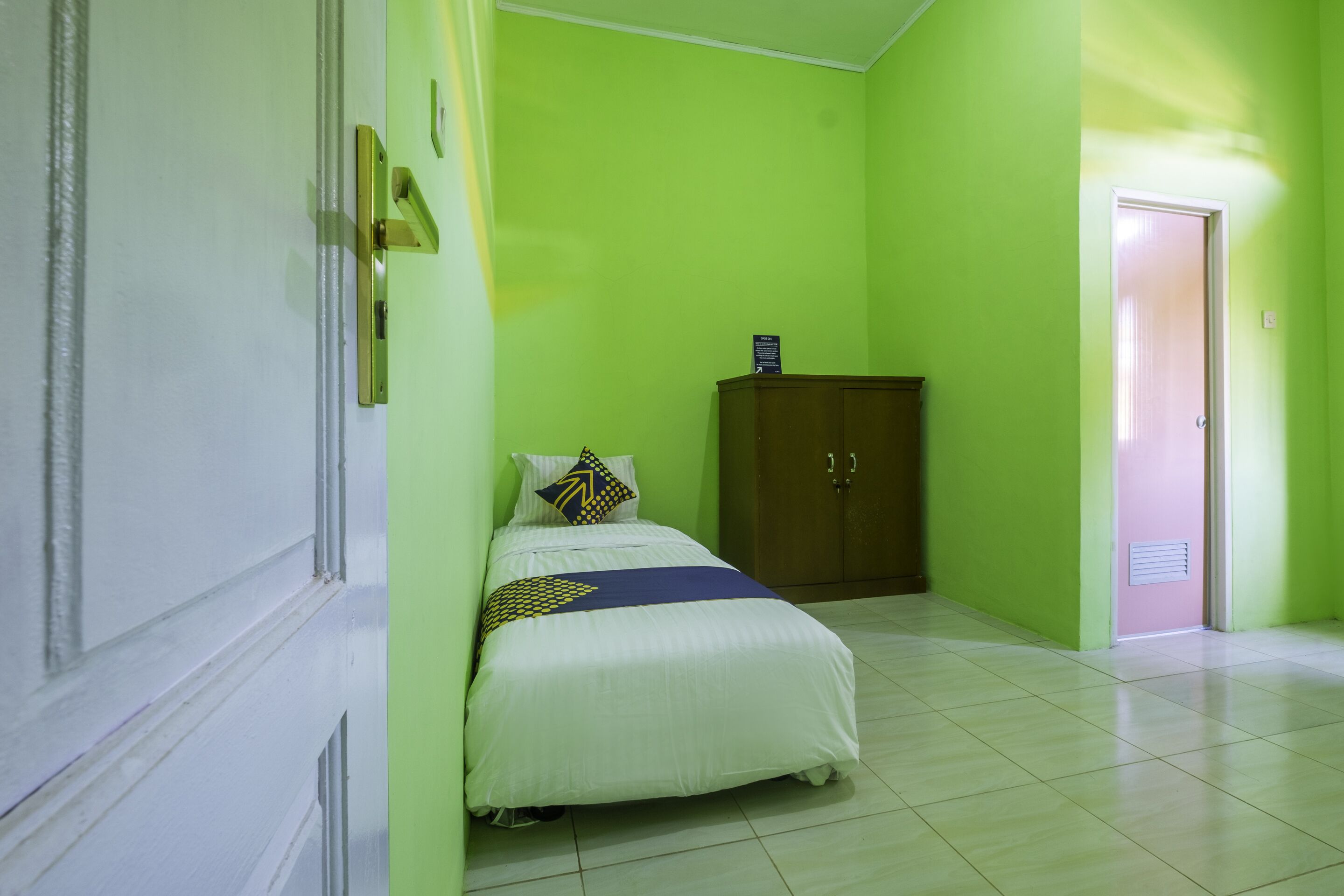 Una habitación con una cama, un armario y una puerta.