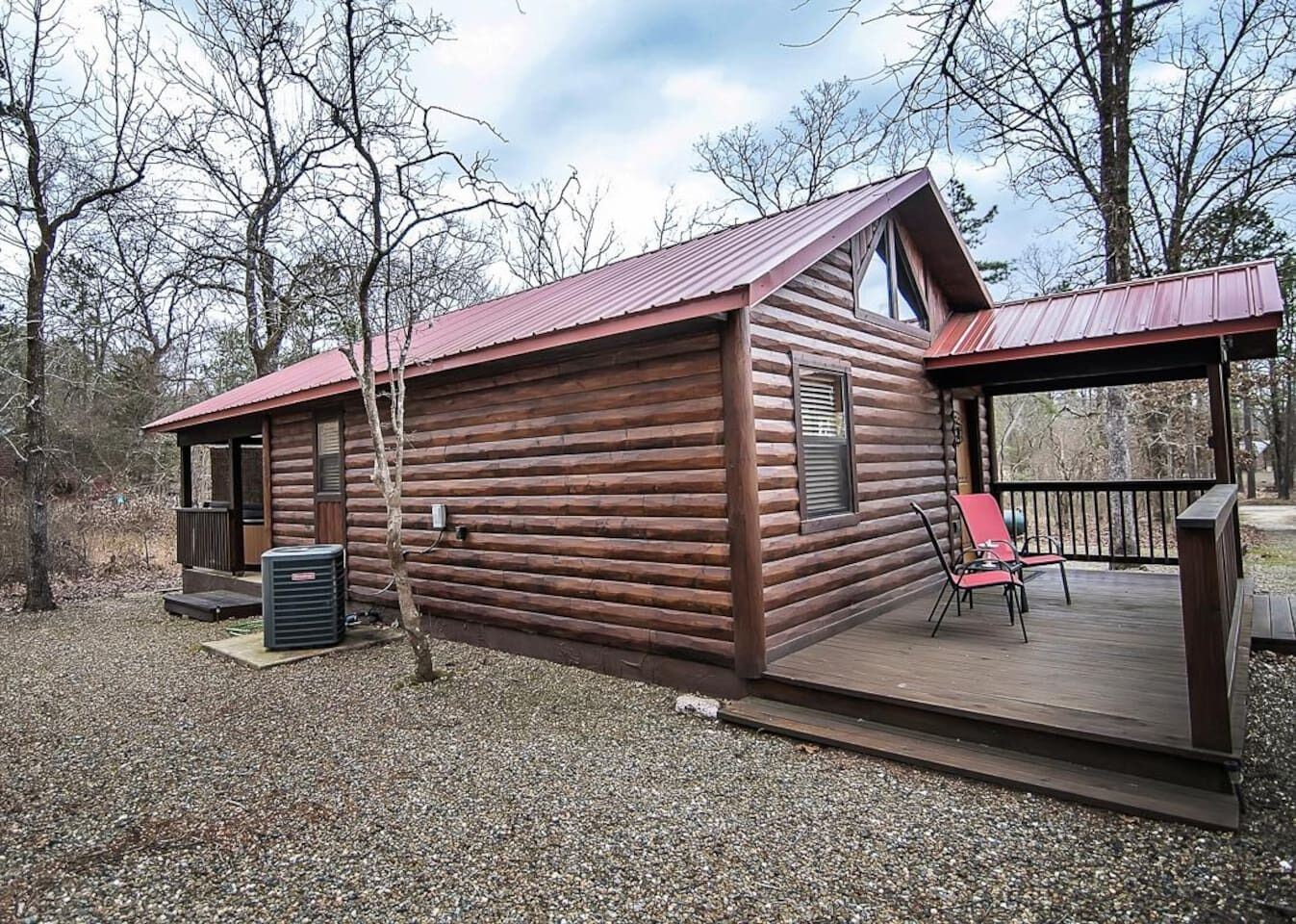 Een vakantiehuis in blokhutstijl met een overdekt terras en een klein voortuintje.