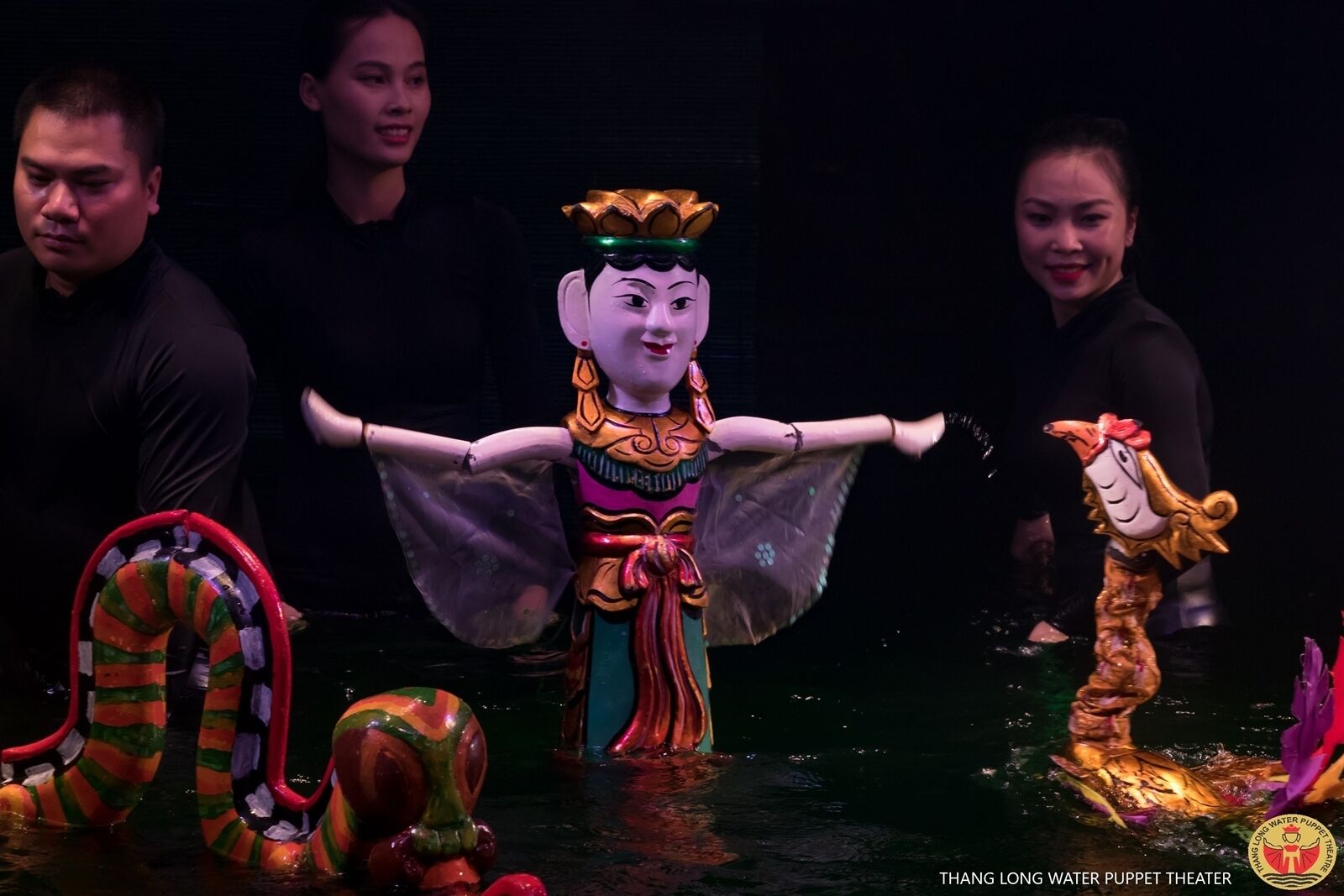 A puppet theater with a central puppet figure and other puppets around it.