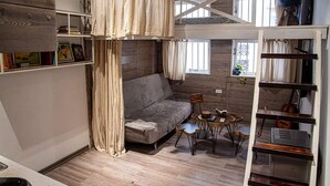 Une pièce chaleureuse avec un canapé, une petite table ronde et une bibliothèque.