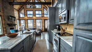 A spacious kitchen with a large island, built-in appliances, and a view through the windows. - Across the Universe - Broken Bow/Hochatown- 3bd (Broken Bow)