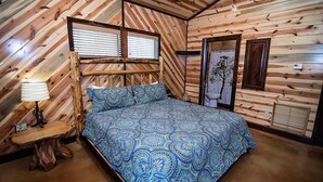 Ein Schlafzimmer mit Bett, Nachttisch, Fenster und Tür.