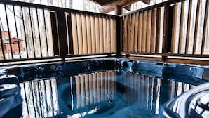 A hot tub with a wooden deck and metal railings. - R-N-R- Broken Bow/Hochatown- 2bd - Sleeps 8 (Broken Bow)
