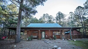 A rustic cabin with a metal roof, wooden exterior, and a porch with benches. - Y Knot- Broken Bow/Hochatown- 2bd (Broken Bow)