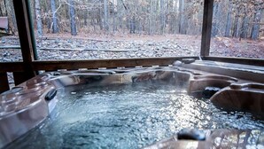 A hot tub with a view of a forested area through a wooden structure. - Y Knot- Broken Bow/Hochatown- 2bd (Broken Bow)