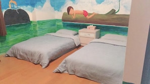 Een kamer met twee eenpersoonsbedden, een nachtkastje en een muurschildering van iemand aan het zwemmen.