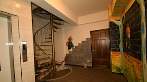 Een trap met een spiraalvormig ontwerp, een houten deur en een kleurrijke muurschildering.