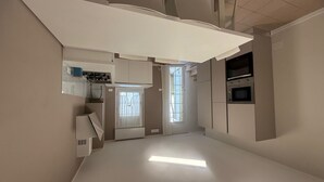 A narrow, modern kitchen with white cabinetry, a built-in oven, and a window providing natural light. - Nice apartment in villa for 8 people with A/C, WIFI, TV, patio and pets allowed (Rosolina)