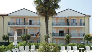 Ein mehrstöckiges Gebäude mit Balkonen, Außenbereich und einer Flagge.